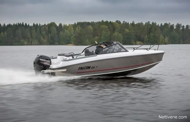 A Falcon BR 7 boat speeds across a lake, showcasing its sleek design and Mercury motor against a forested backdrop.